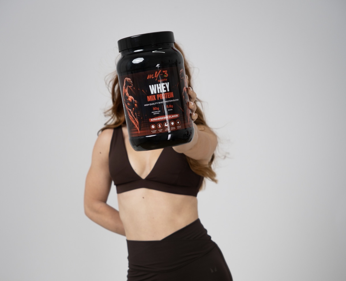 Teodora Cara ținând o cutie de proteină MY3 Sports Whey Mix