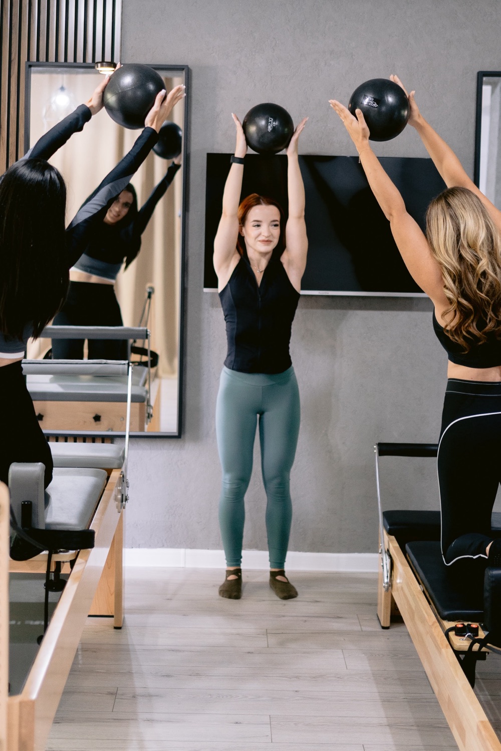 Teodora Cara ghidând o clasă de Pilates pe Reformer cu mingi